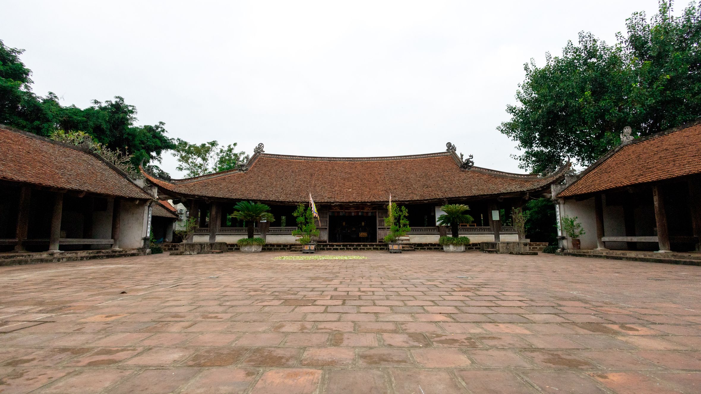 Explore the serene beauty of a traditional Vietnamese temple courtyard in Hà Nội, captured on a clear day.