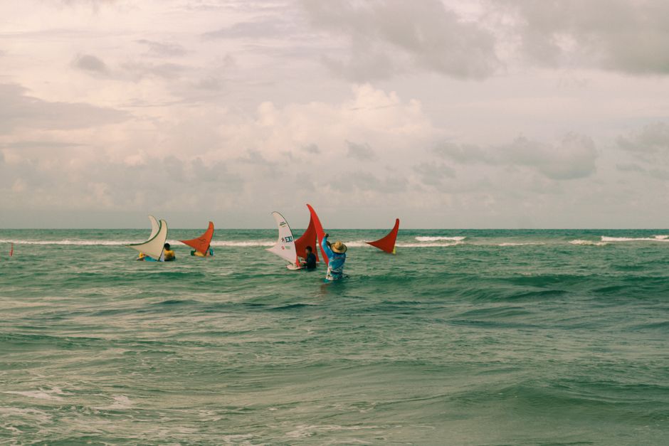 Immerse in the vibrant scene of jangada boats sailing on a Brazilian beach.