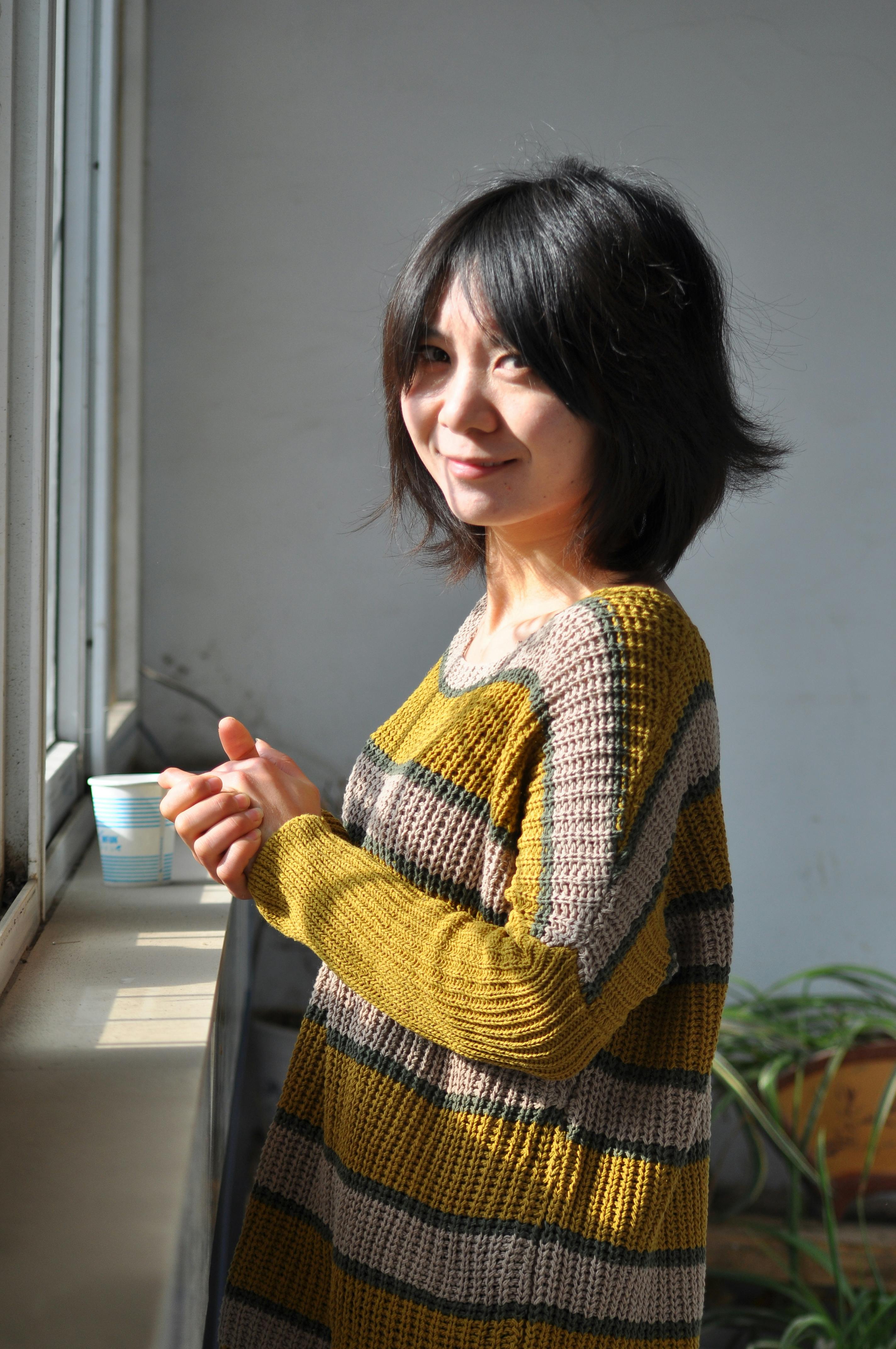 Casual shot of a woman enjoying sunlight and coffee by a window indoors.
