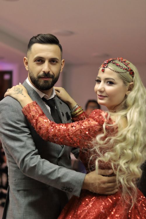Free A couple elegantly dancing at an indoor event, dressed in formal attire with traditional accents. Stock Photo