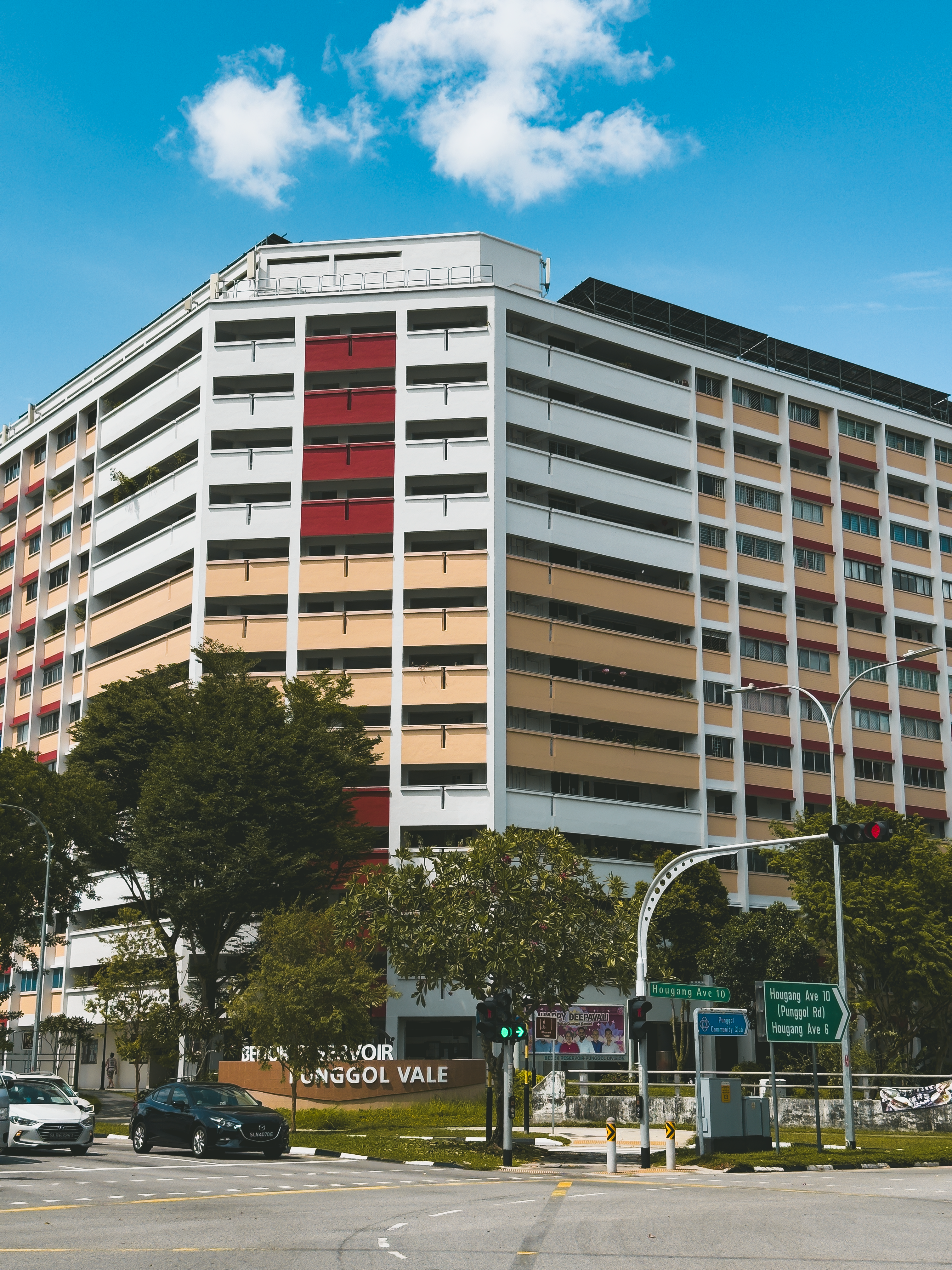 Vibrant residential building in urban setting under clear blue sky, showcasing urban architecture.