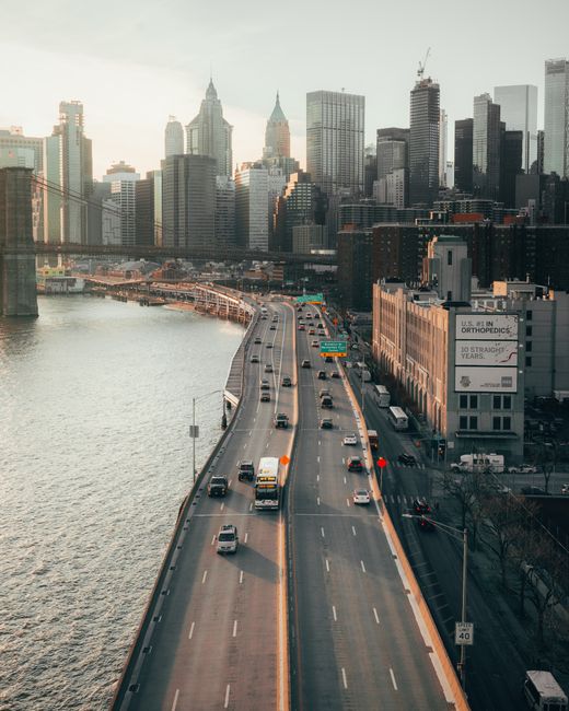 Stunning aerial shot of New York City's Manhattan skyline with a busy highway and river in view.