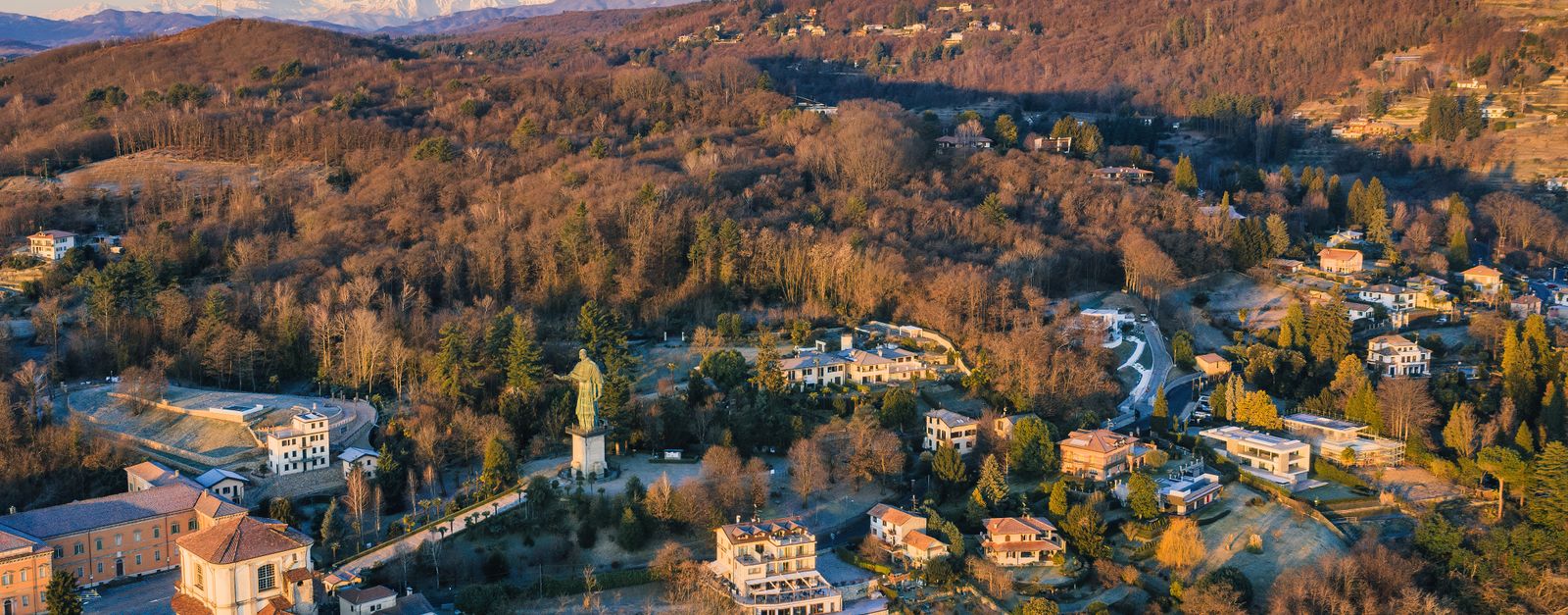 Scenic aerial view of Sacro Monte di Orta during winter, showcasing historical architecture and mountainous landscapes.