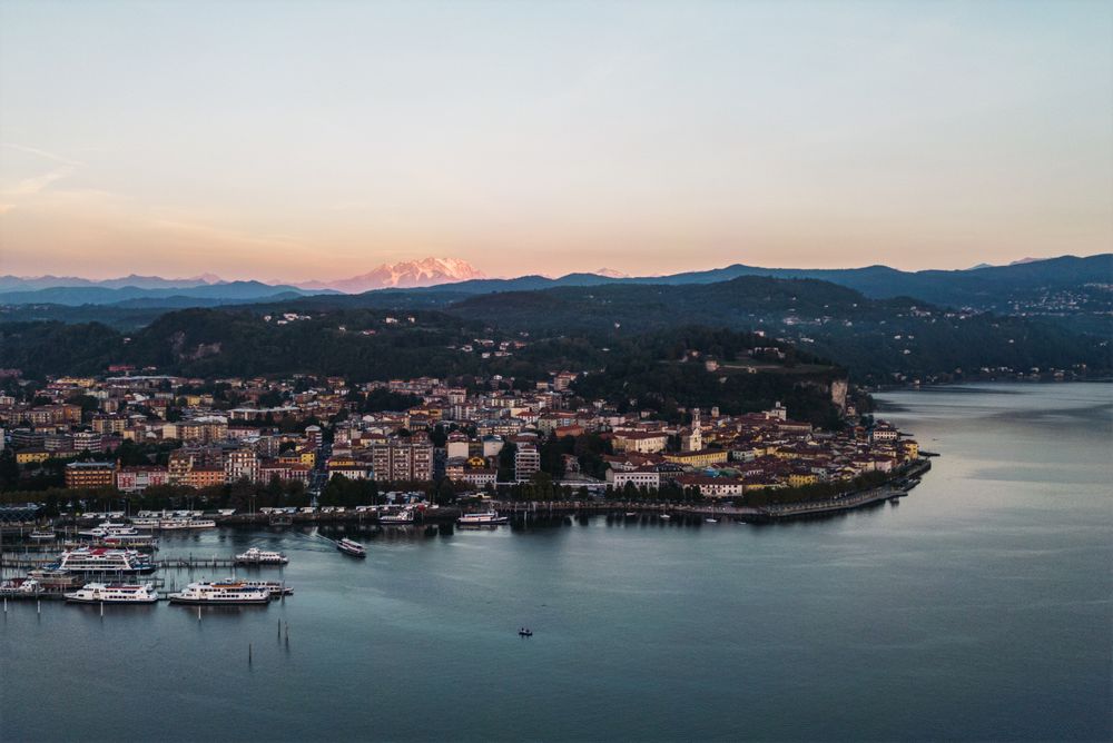 Vedere aeriană a Lacului Maggiore cu Alpii în fundal, la apus