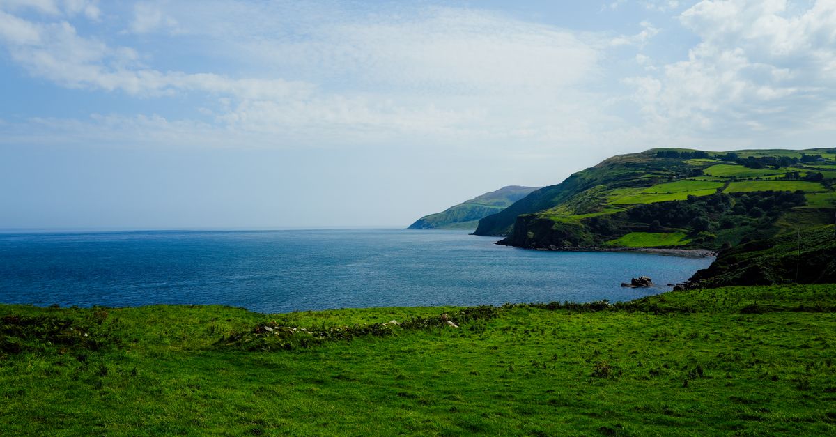 Green hills dropping to the sea under an open sky
