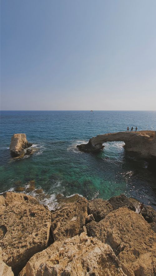 Free Stunning natural rock arch over the sea with clear blue skies in Cyprus, ideal for travel and nature themes. Stock Photo