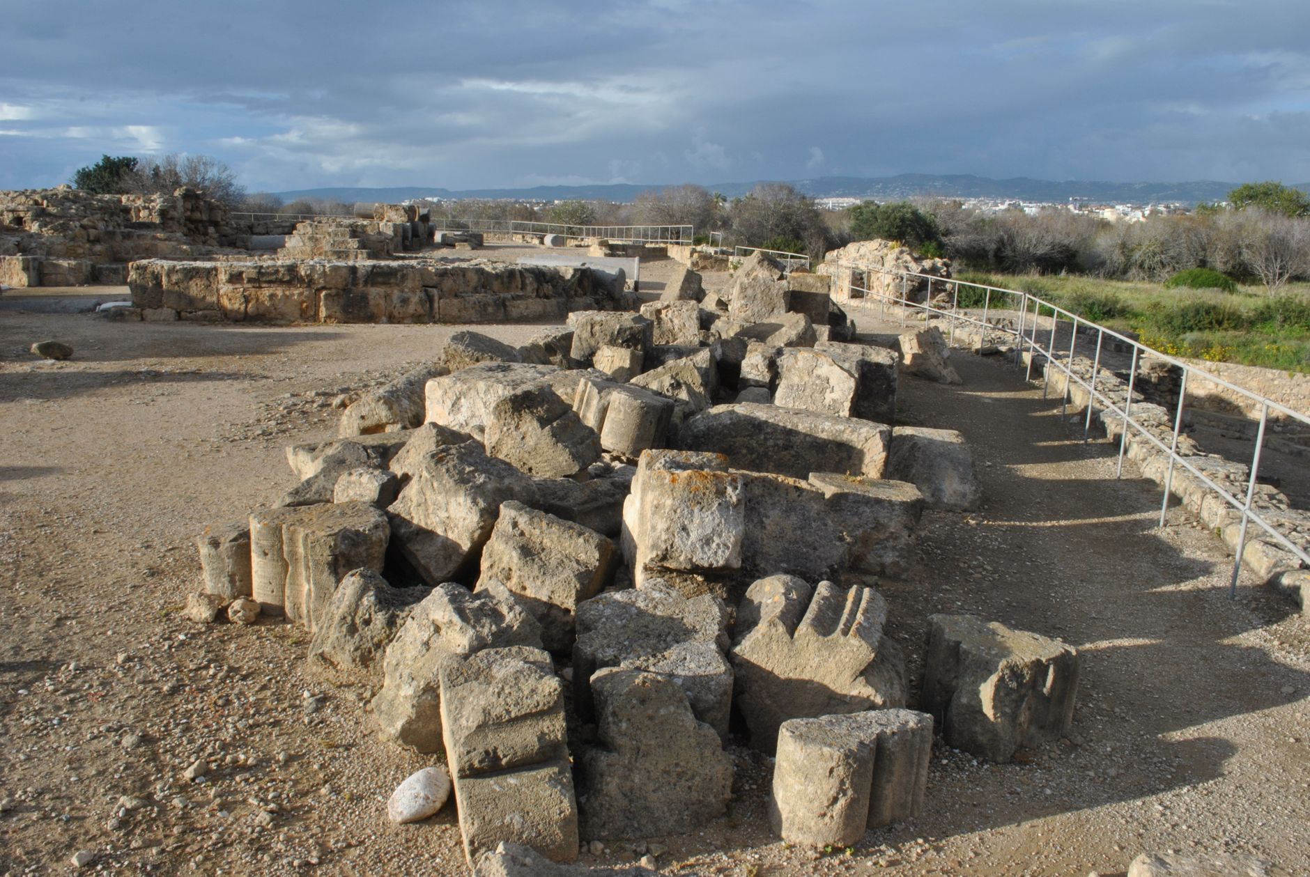 Scenic view of ancient ruins with fragmented stone columns and overcast skies.