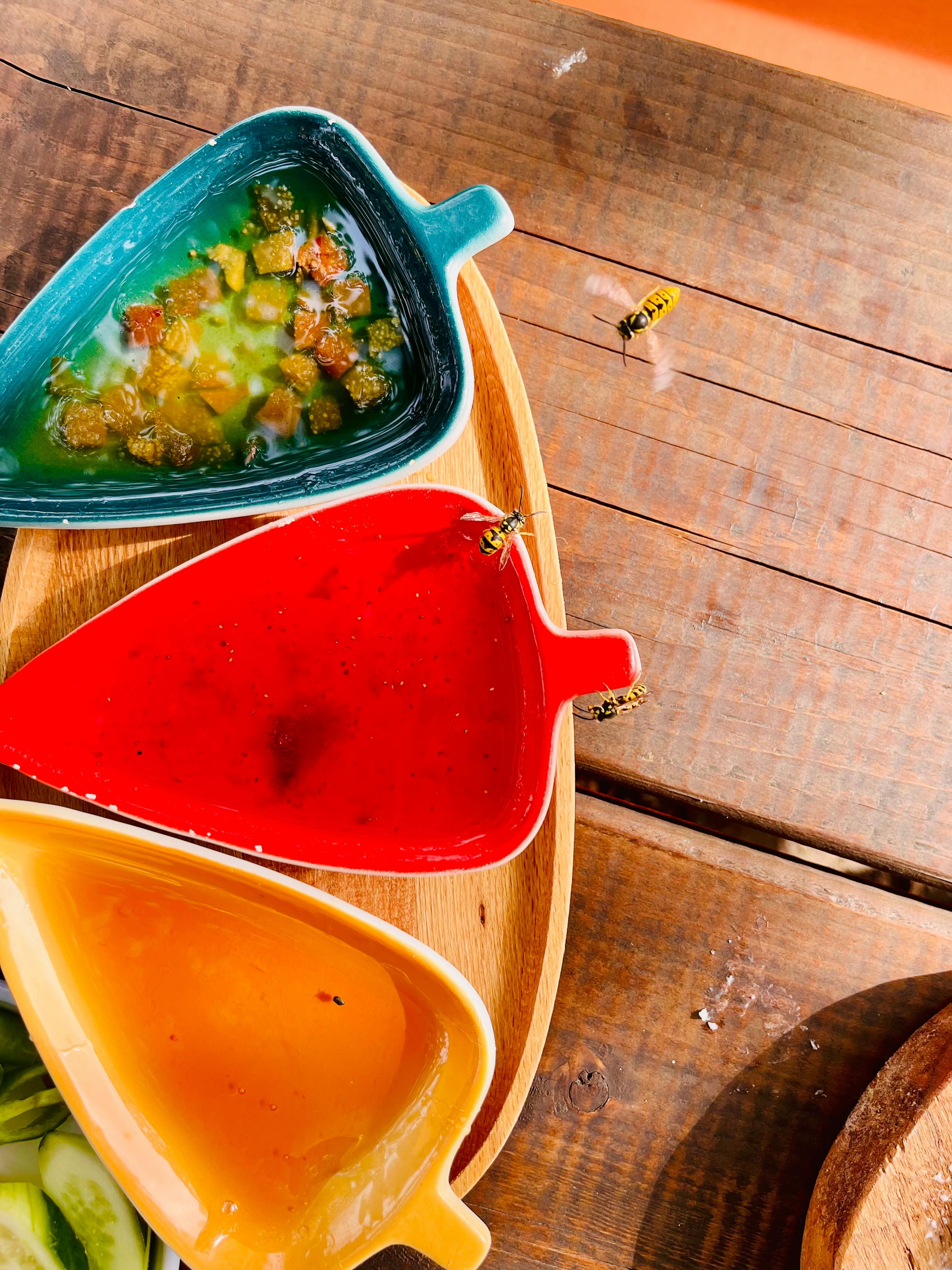 colorful condiments in dish with wooden background