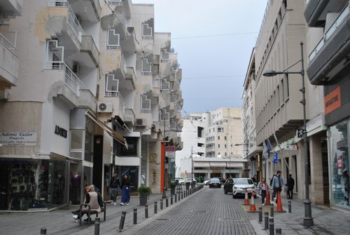 Free Captivating street view featuring distinctive building architecture and lively pedestrians. Stock Photo