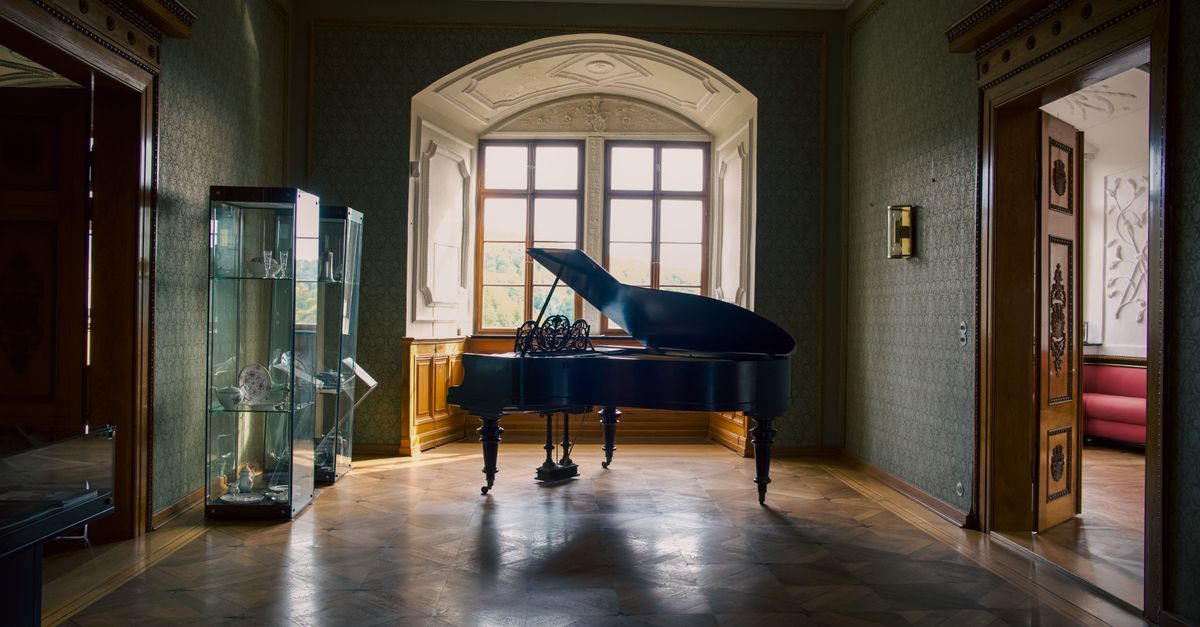 A grand piano illuminated by soft light in a luxurious room of Stolberg Castle, Germany.