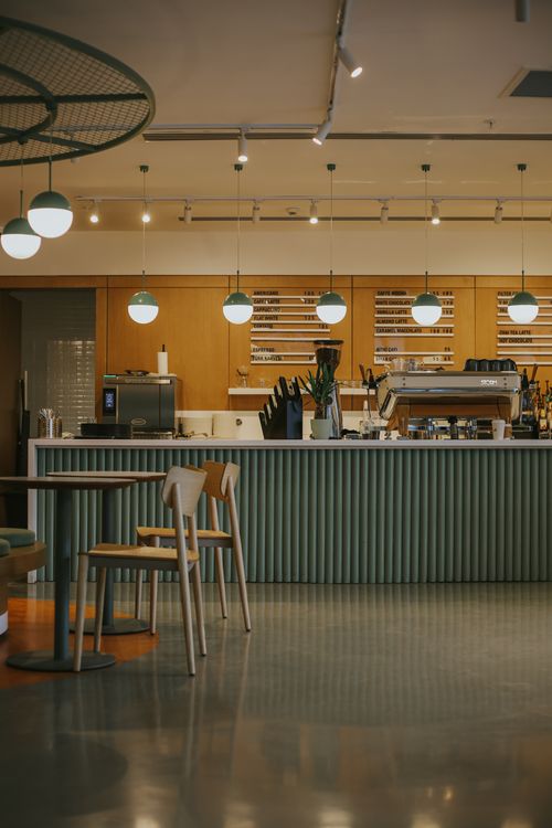 Free A stylish modern cafe interior featuring a sleek barista bar with ambient lighting, perfect for a relaxing coffee shop experience. Stock Photo