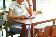 白天在咖啡馆穿着随便使用平板电脑和智能手机的女人