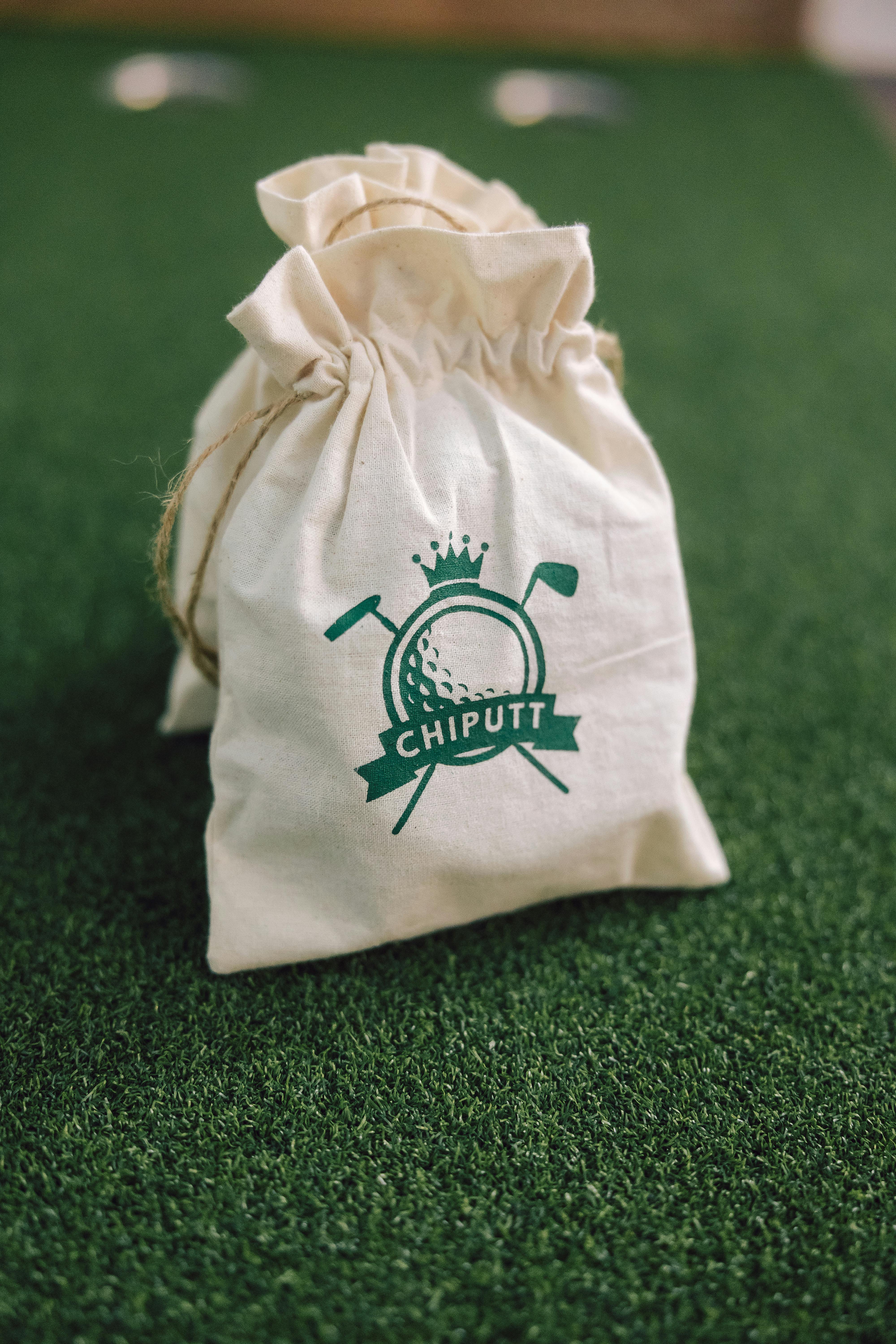 A golf equipment bag labeled 'Chiputt' placed on artificial turf, ideal for golf practice.