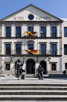 The façade of Teatro Cervantes in Alcalá de Henares with Don Quixote statues on a clear day.