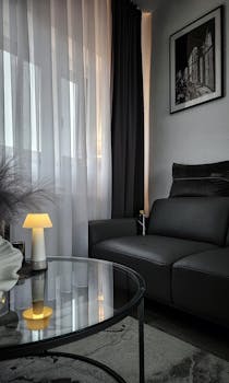 Sophisticated living room with dark aesthetic and modern furnishings, offering a cozy atmosphere.