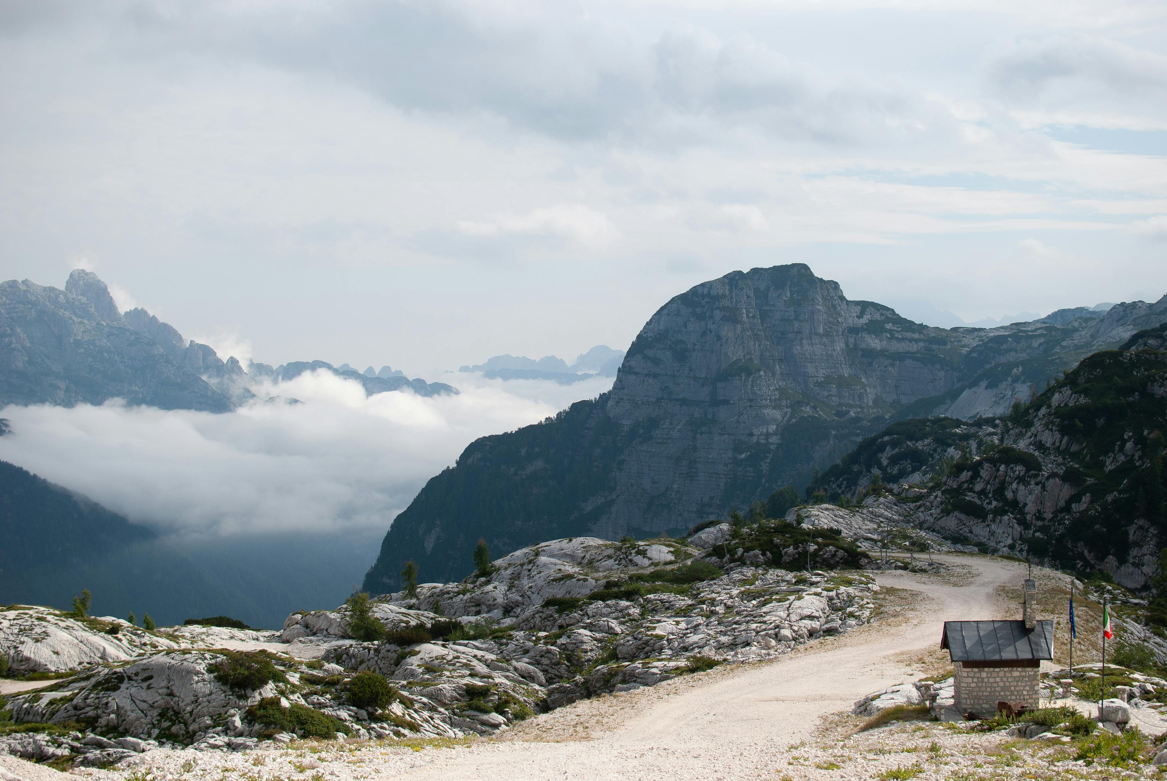 Dramatic mountain landscape with a rocky path in the Dolomites under a cloudy sky.
