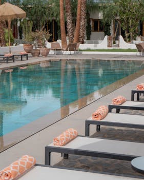 Serene poolside view with sun loungers and rolled towels at a luxurious resort.