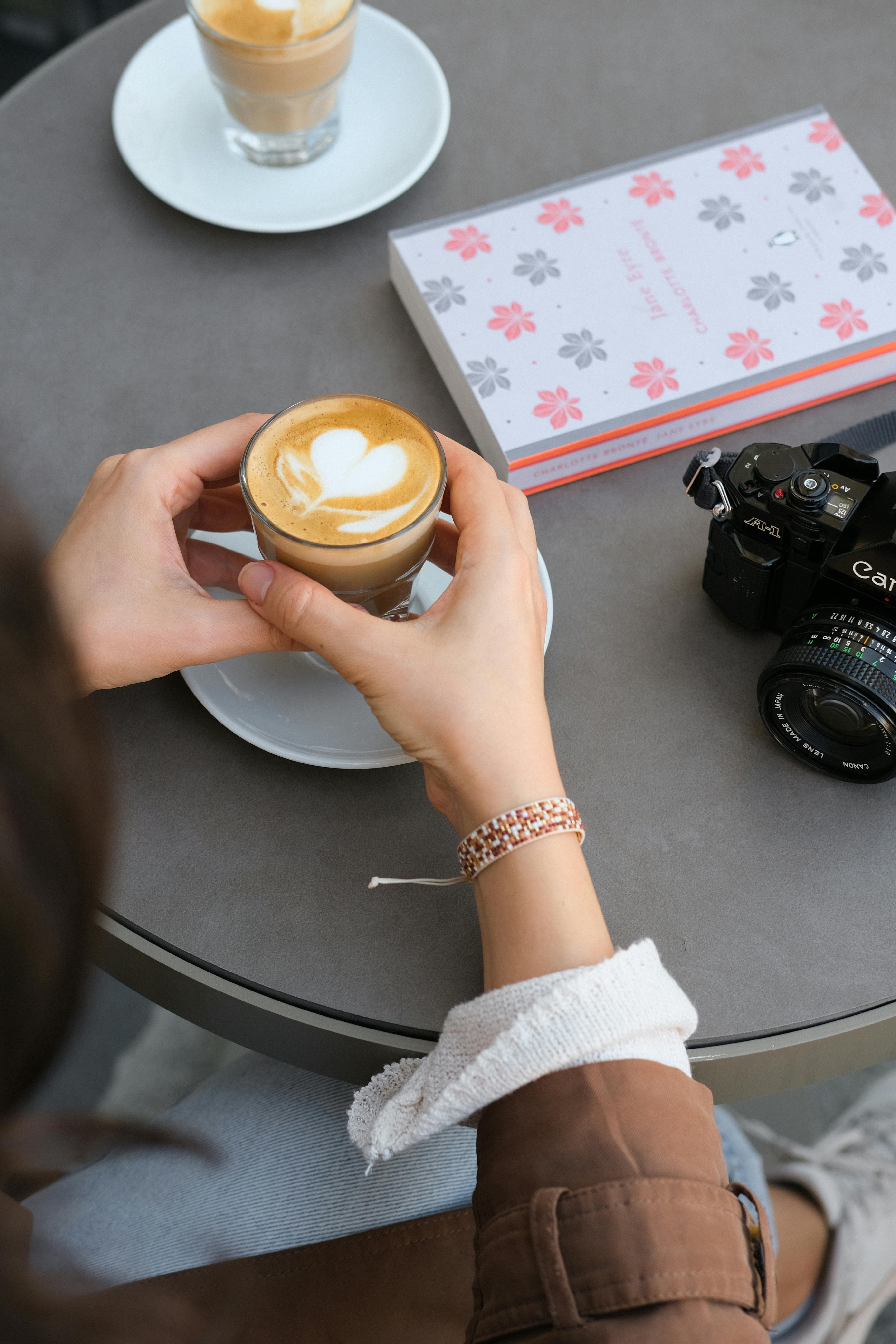 Cappuccino with latte art next to a camera in a cozy Istanbul café.
