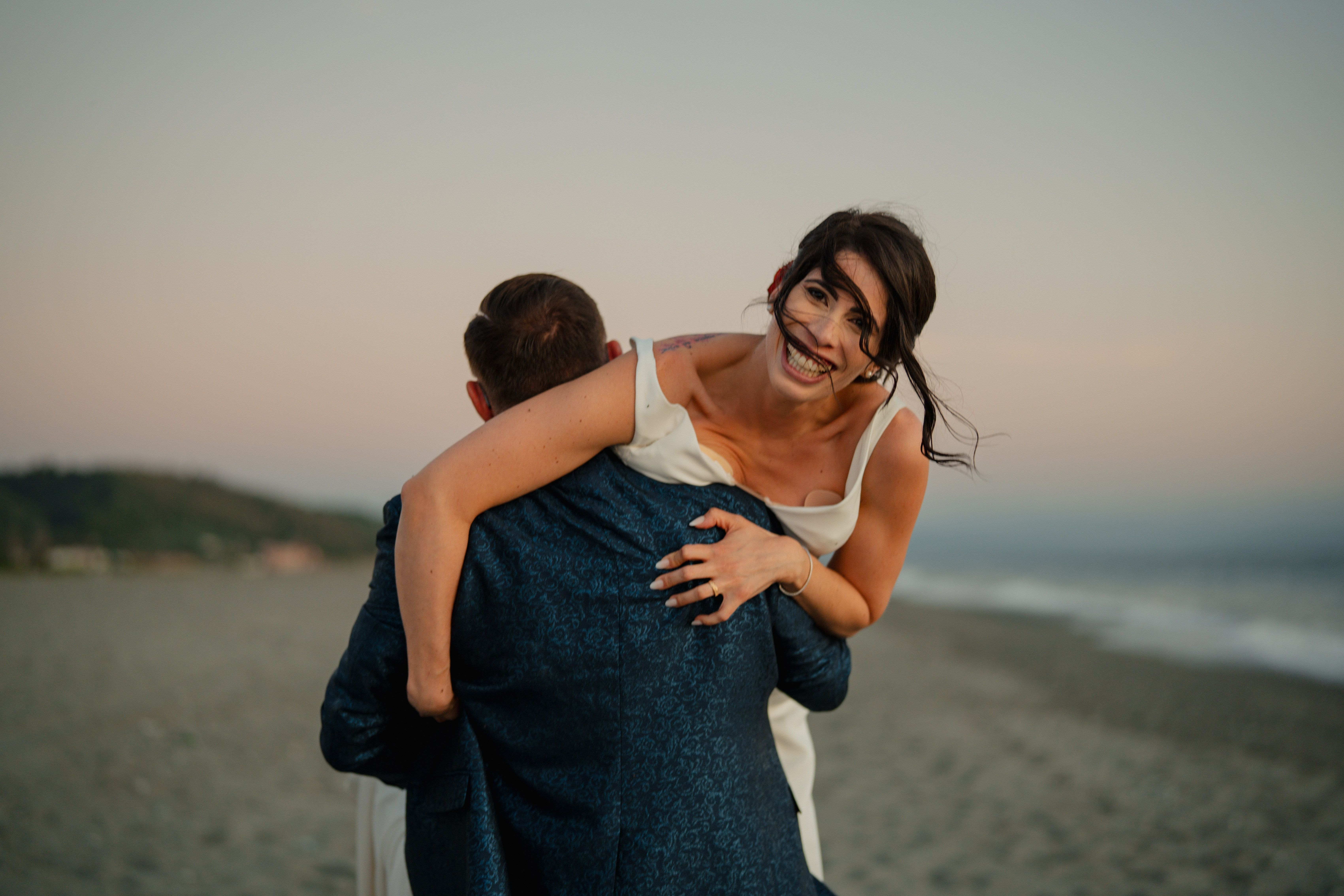Joyful Couple Embracing on Beach at Sunset · Free Stock Photo