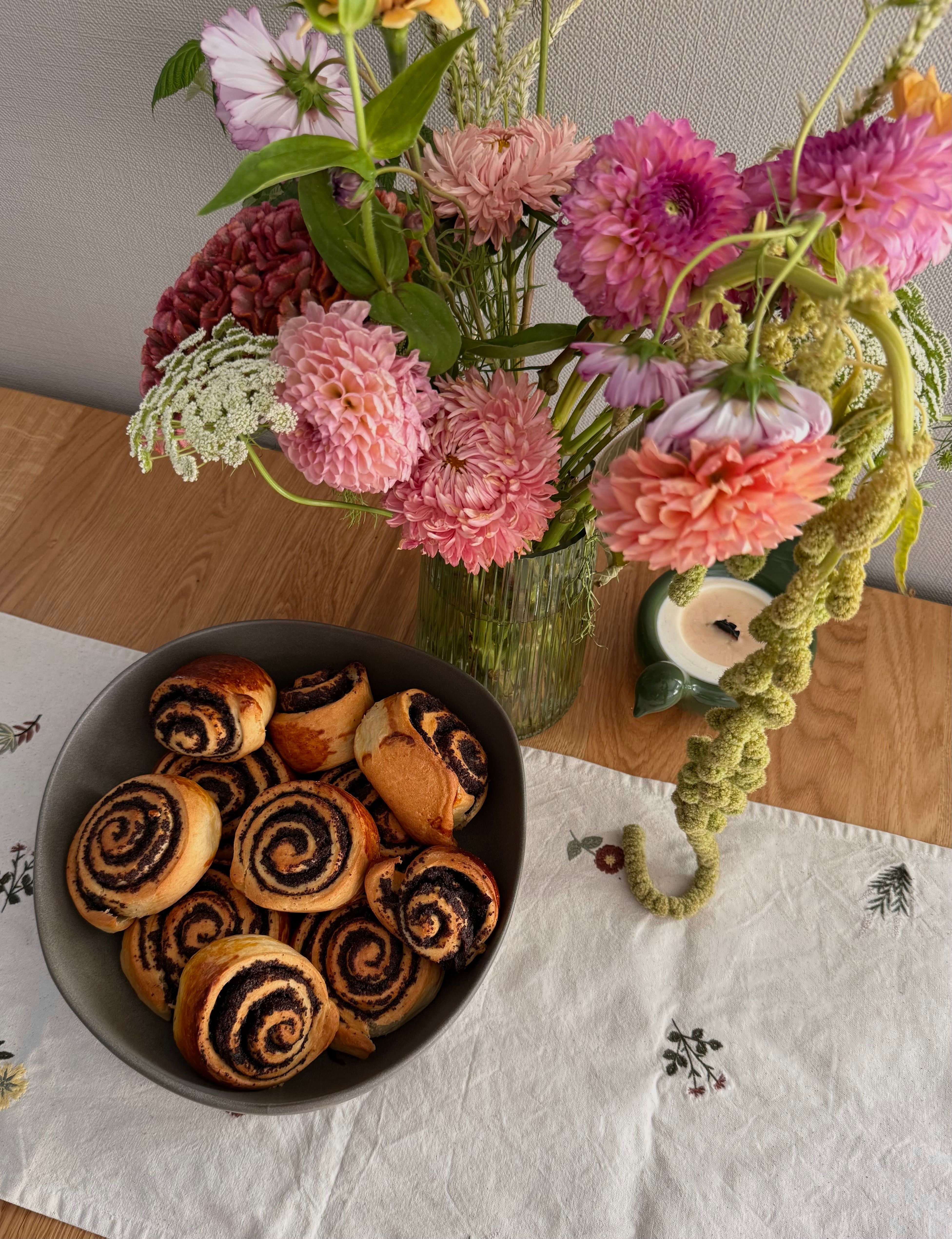 Colorful flowers and cinnamon rolls create a cozy autumn setting.