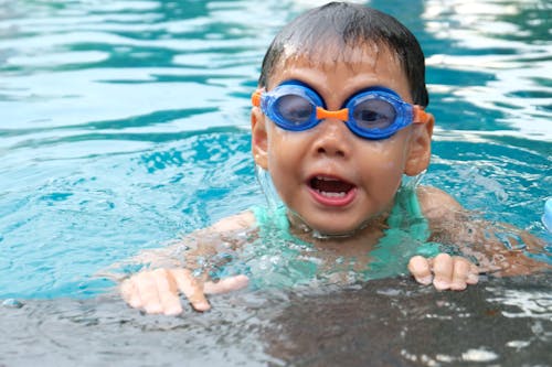 Toddler Swimming on Pool Wearing Blue Goggles