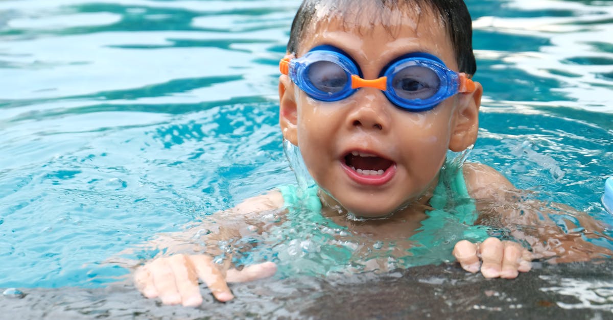 Toddler Swimming on Pool Wearing Blue Goggles