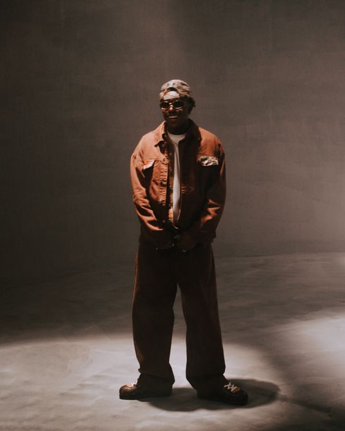 Free Artistic portrait of a stylish man in a dimly lit studio with vintage tones. Stock Photo