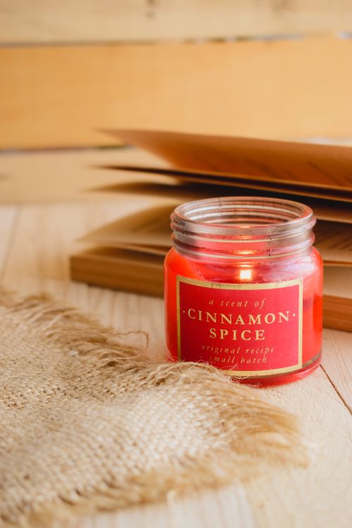 Free Warm autumn ambiance with a cinnamon-scented candle and book pages. Stock Photo