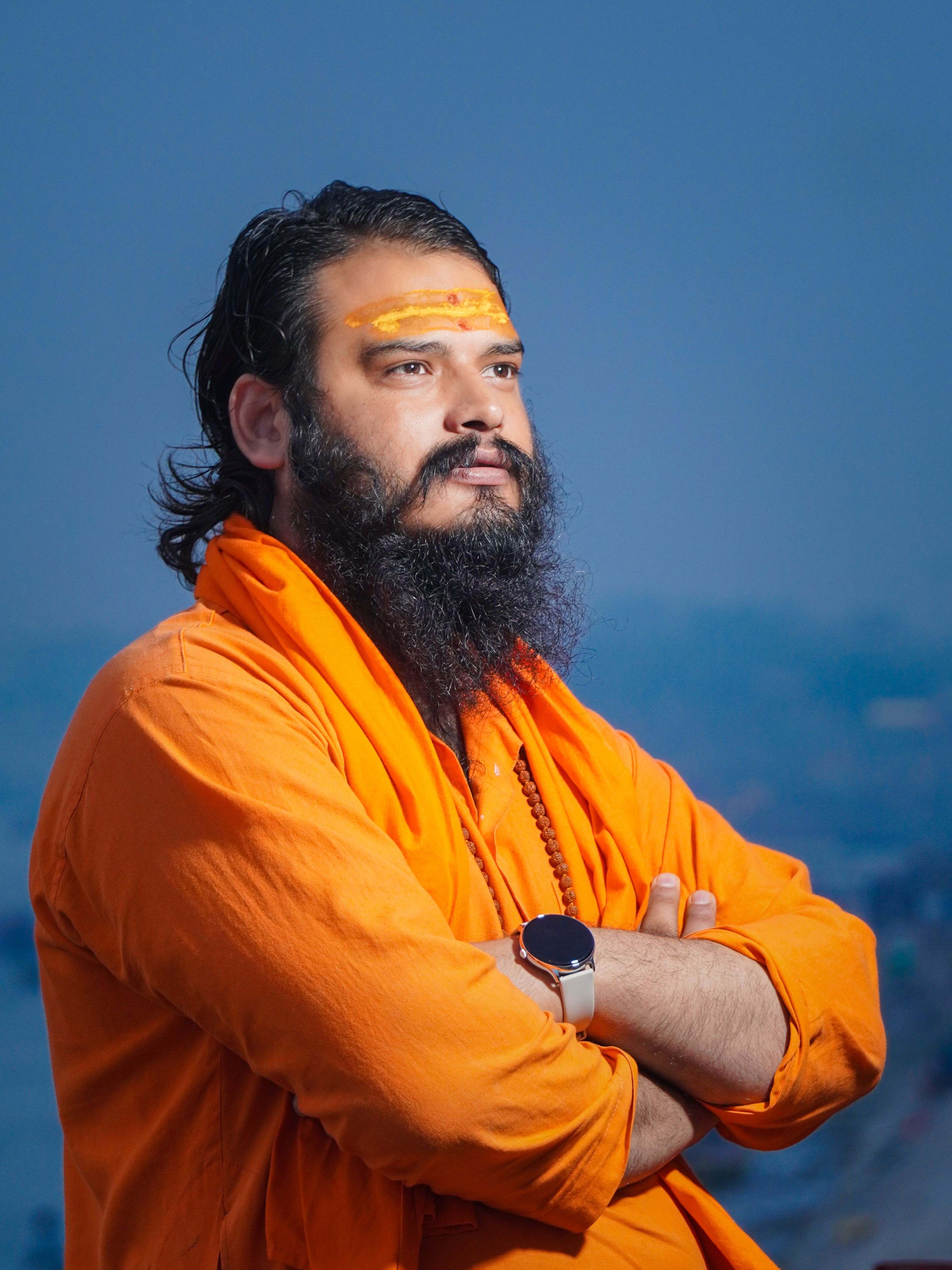 Introspective portrait of a holy man dressed in orange robes in Varanasi, India.