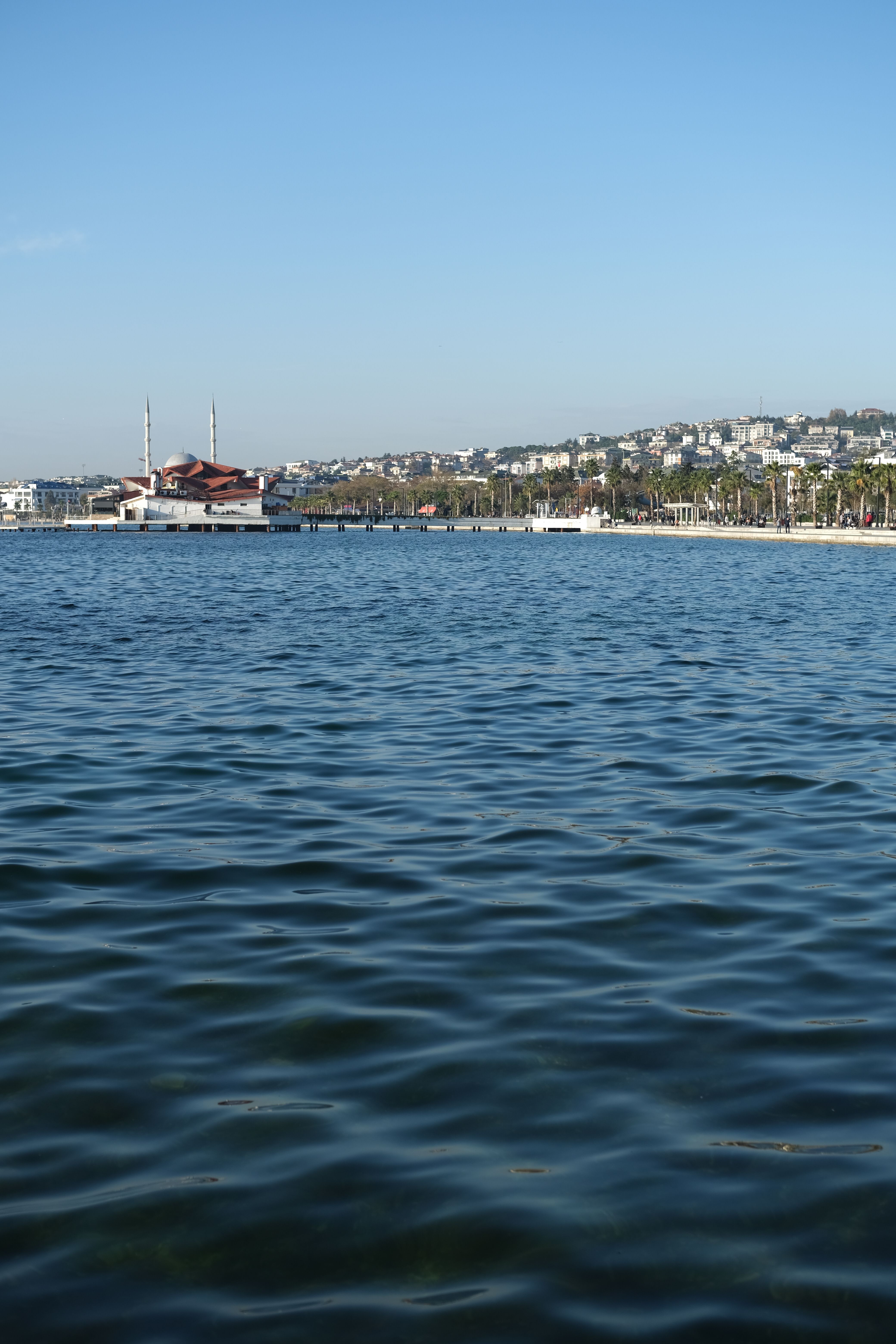 Serene view of the Büyükçekmece coastline with clear blue waters and cityscape in Istanbul, Turkey.