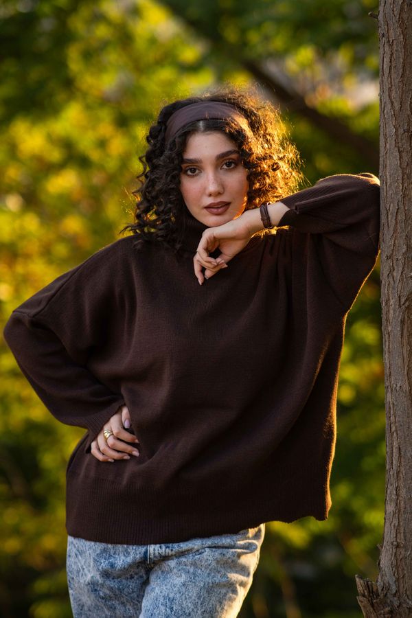 Woman wearing a chestnut balloon-sleeve sweater with dark jeans