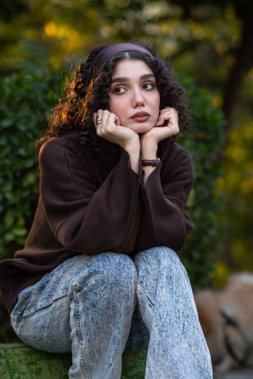 Thoughtful Woman Sitting Outdoors in Autumn · Free Stock Photo