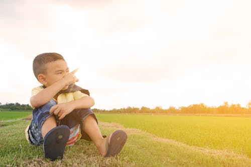 Boy Sits on Grass