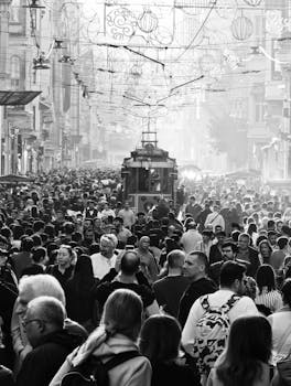 A crowded Istiklal Avenue in Istanbul with the iconic tram, captured in black and white.