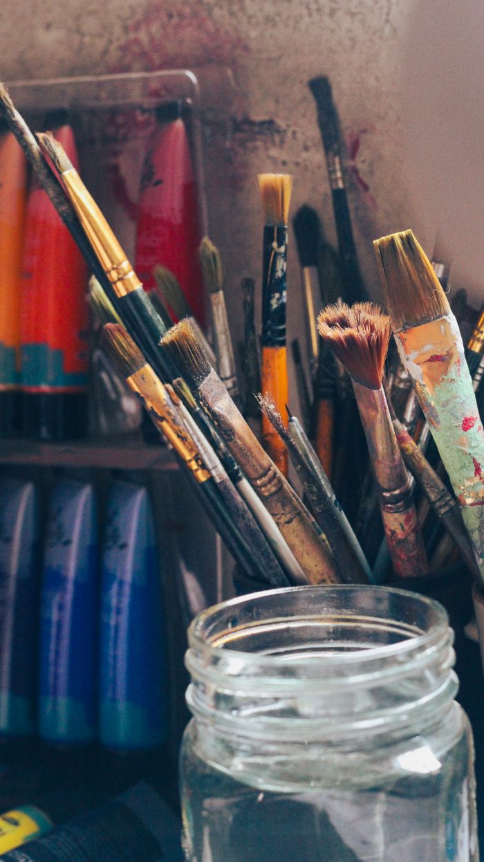 Brushes standing beside tubes of paint