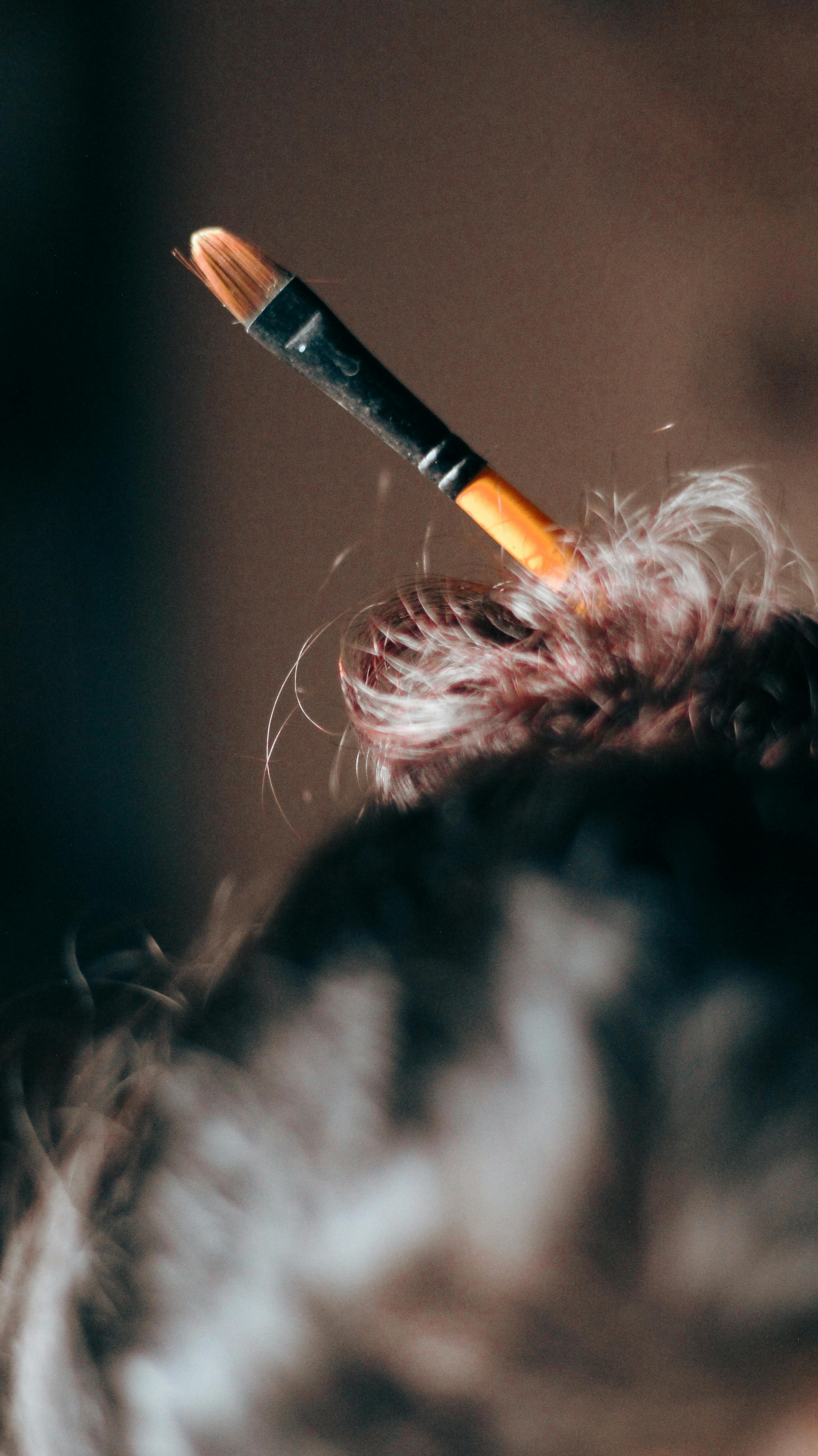 A close-up of a brush tucked into a hair bun, showcasing creativity and art style.