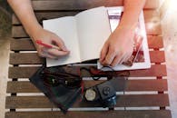 Person Writing on Book Page