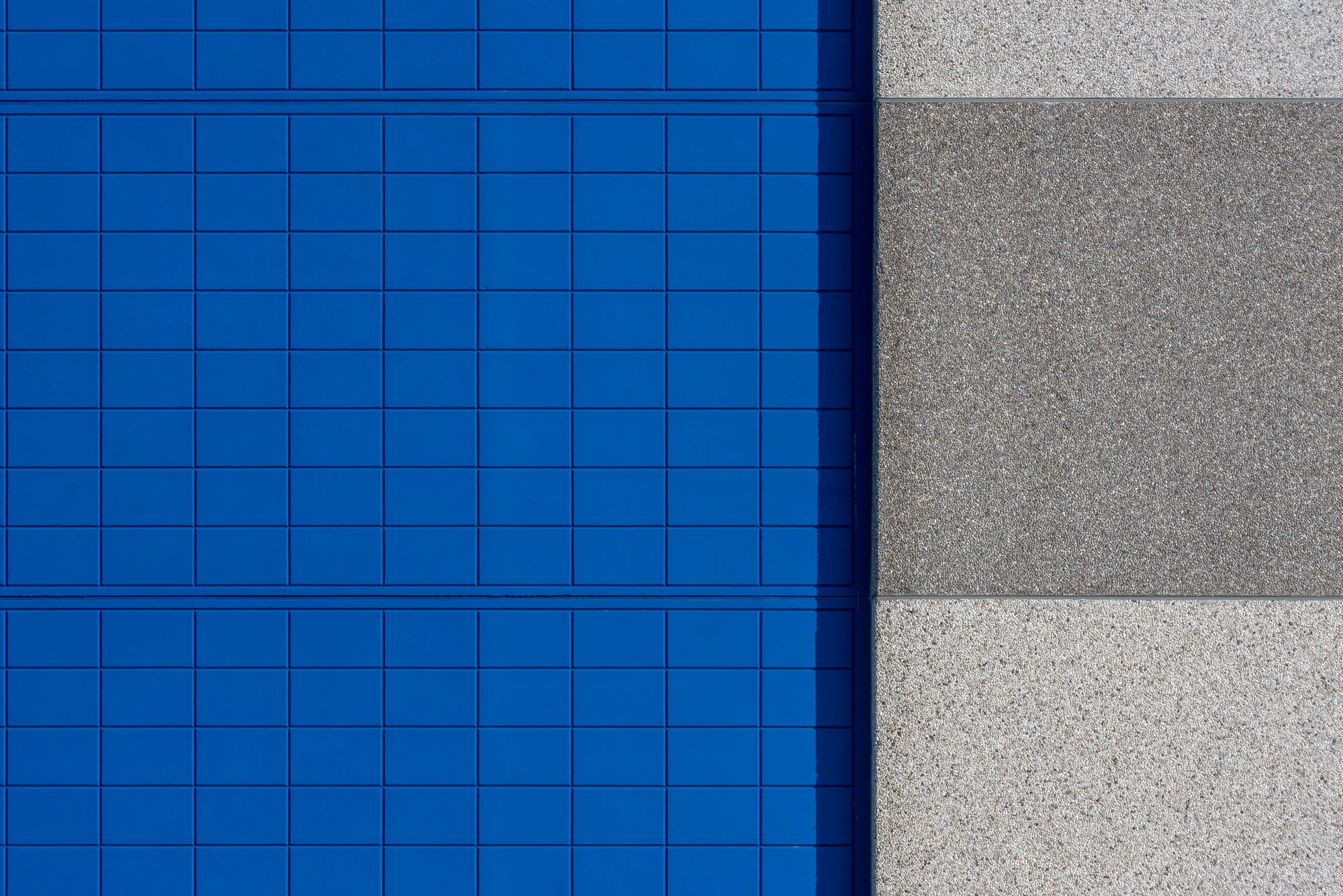 A blue and grey building facade with a repeating geometric pattern