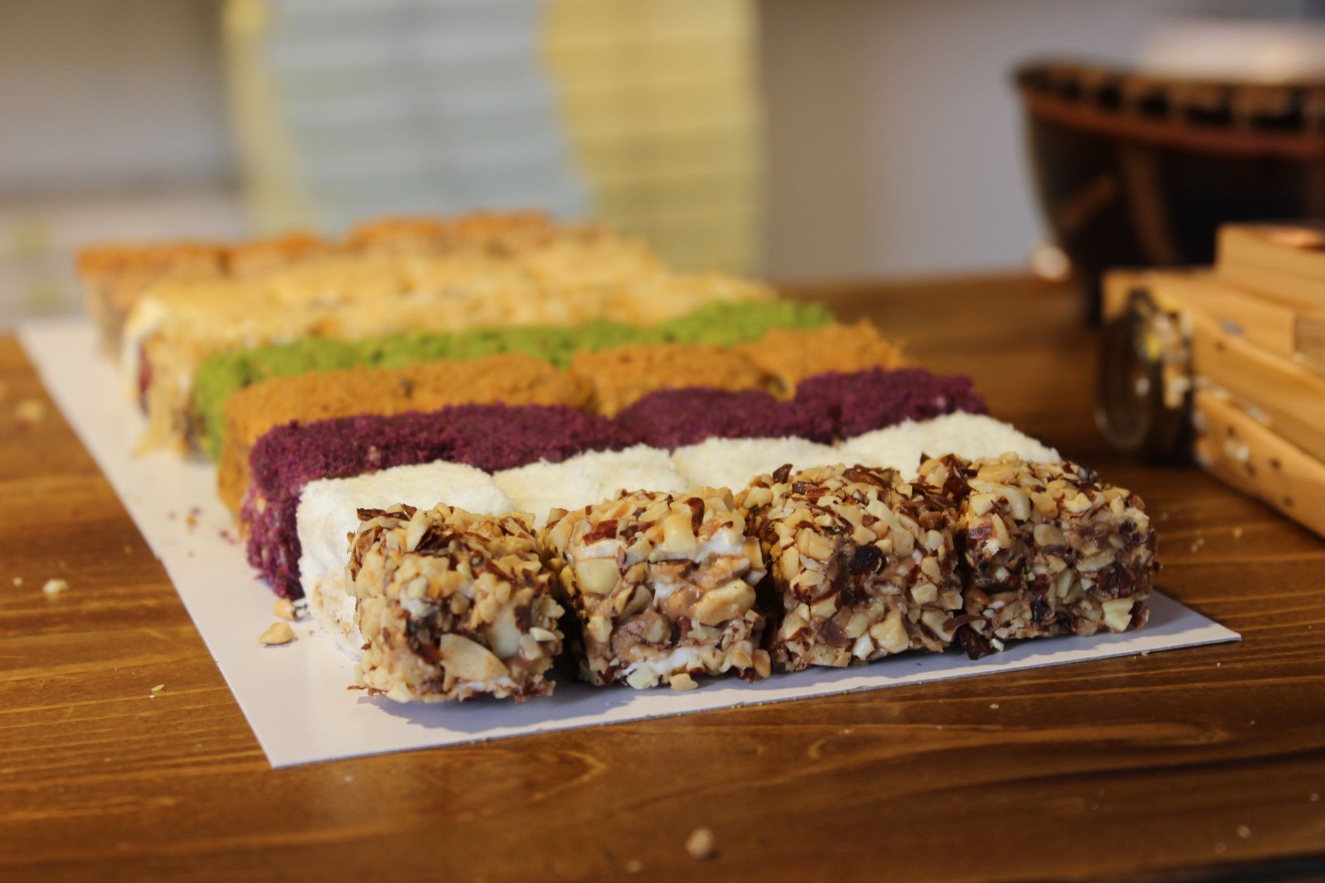 Vibrant array of Turkish desserts featuring nuts and colorful coatings on a wooden table in Karabük, Türkiye.