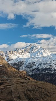 Majestic view of snow-capped Alps under a bright blue sky in Madesimo, Italy.