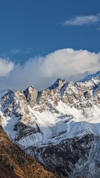 Snow-covered mountain peaks under a blue sky in Madesimo, Italia. Stunning alpine scenery.