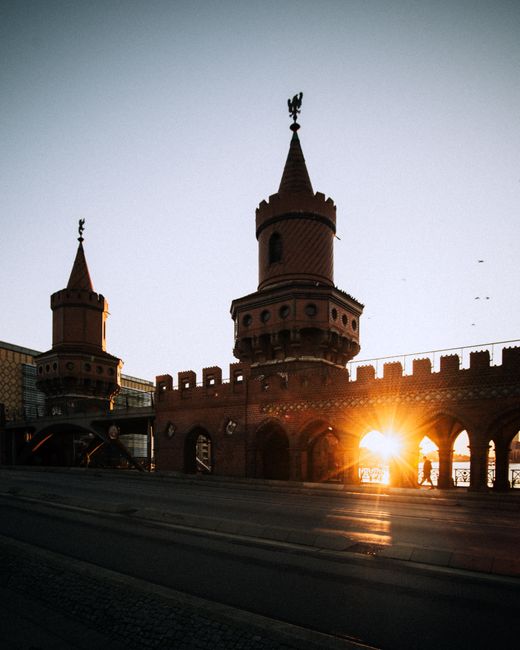 Sunset over Oberbaum Bridge in Berlin with its iconic arches and towers.