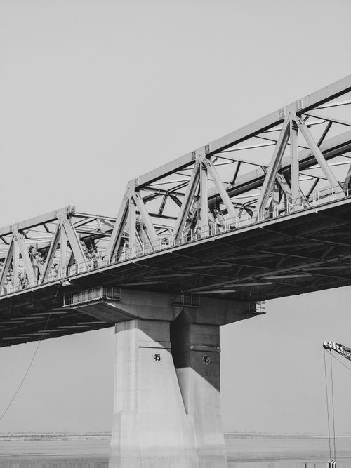 Free A detailed black and white view of a steel bridge, showcasing its architectural elements. Stock Photo