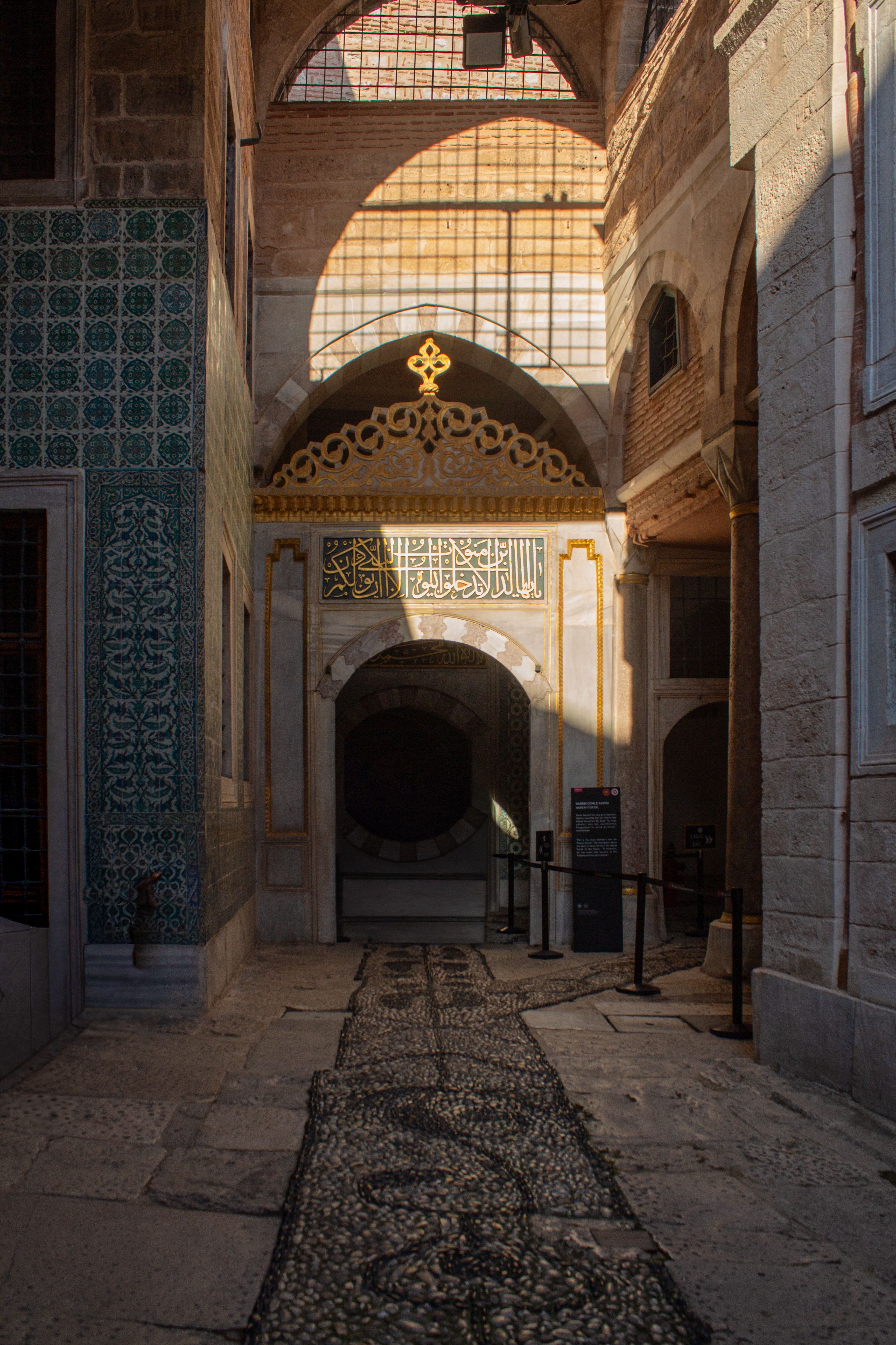 Sunlit corridor highlighting Ottoman architectural details and intricate tile work.