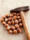 Rustic Hammer and Hazelnuts on Wooden Surface