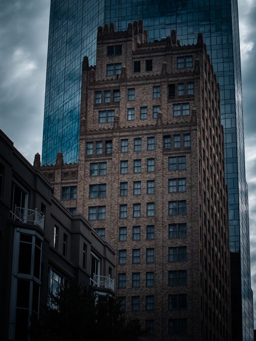 Free Historic building reflection in modern glass skyscraper, a blend of old and new architecture. Stock Photo