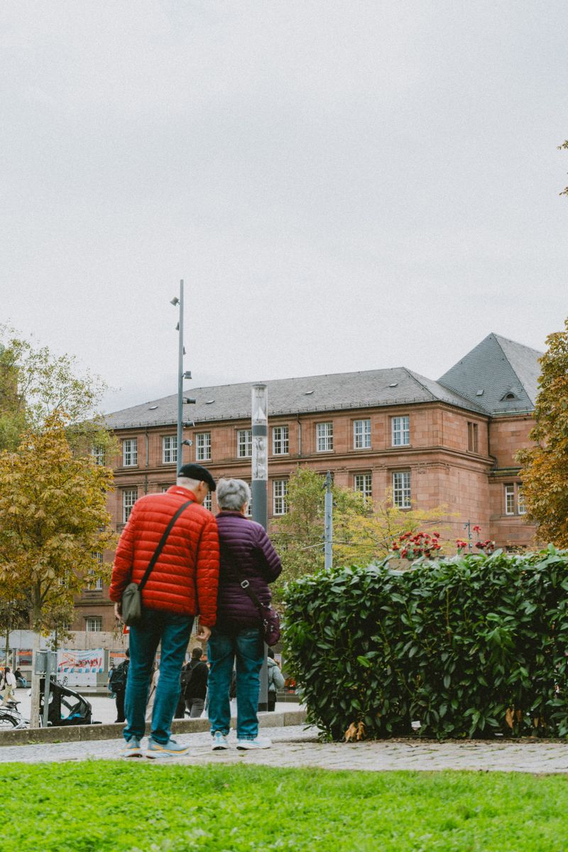 Senior couple in Freiburg, Germany, admiring historic architecture in autumn.