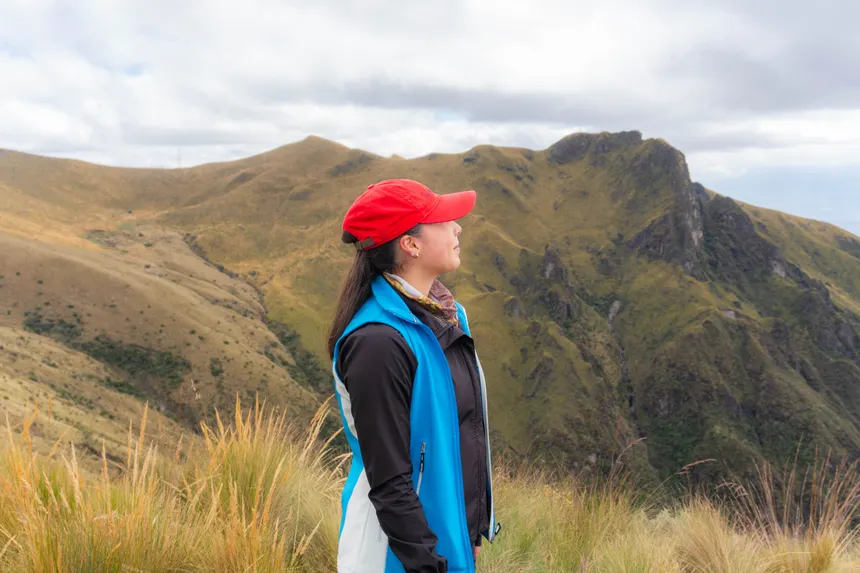 Woman in red cap admiring the Andes Mountains in Quito, Ecuador.