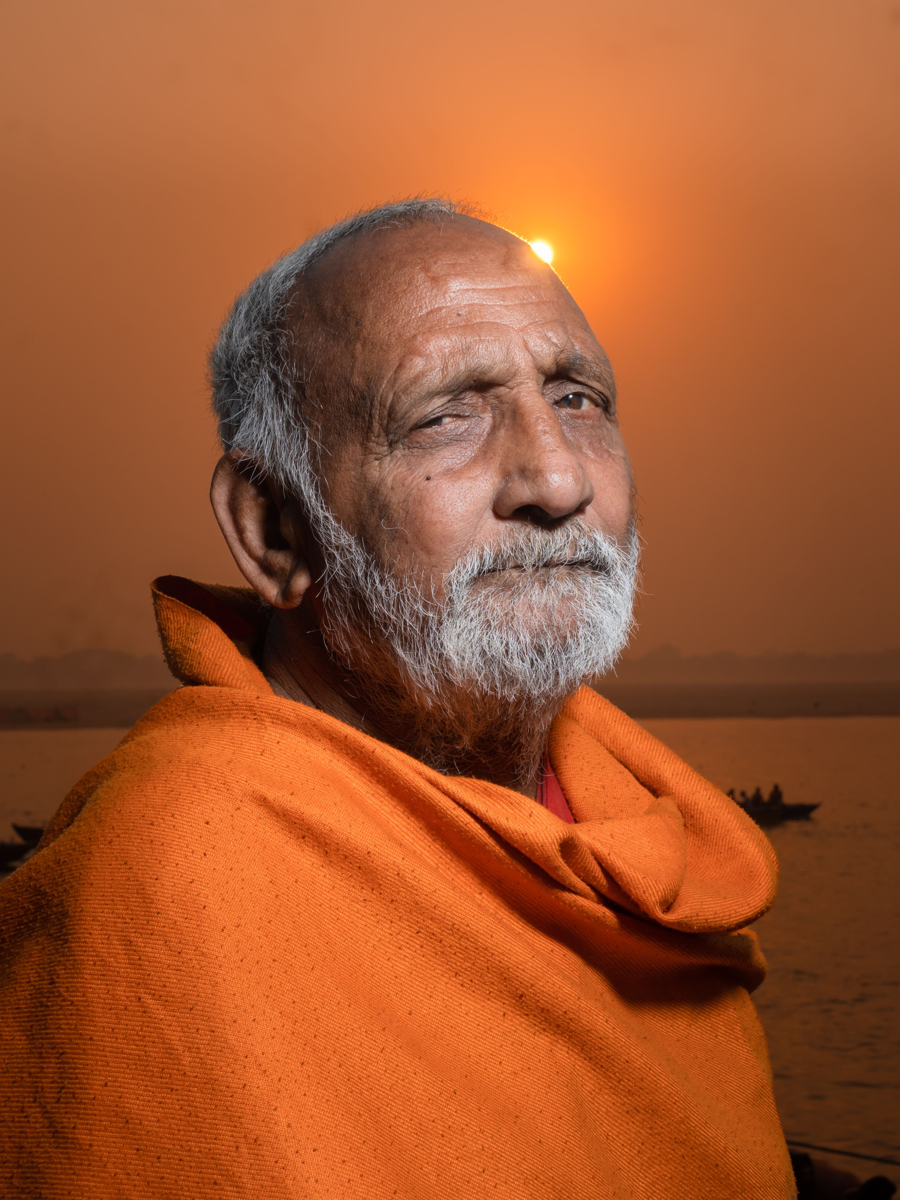 Captivating portrait of a Hindu sadhu in Varanasi at sunset, wrapped in saffron attire.