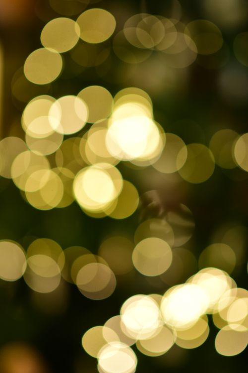 Free Golden bokeh lights create an abstract and festive pattern, perfect for holiday themes. Stock Photo